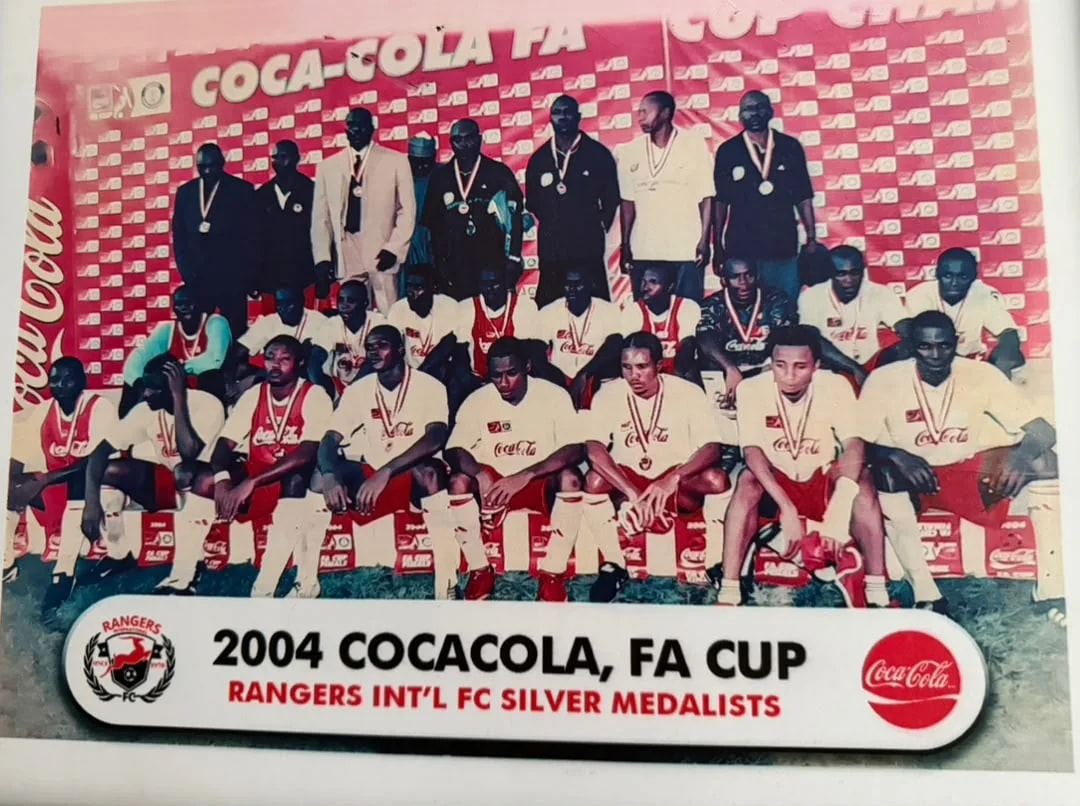 Rangers players and officials wearing silver medals in front of a Coca-Cola FA Cup backdrop.